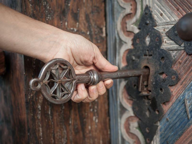 Image showing a hand unlocking a door with a giant key to represent how a PhD can unlock students' potential