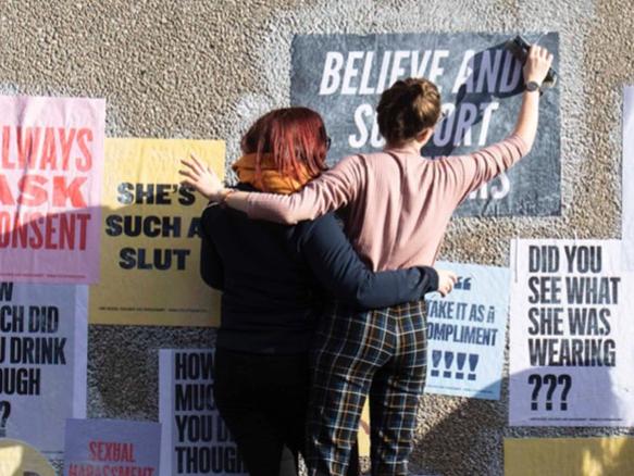 Women posting anti-harassment posters