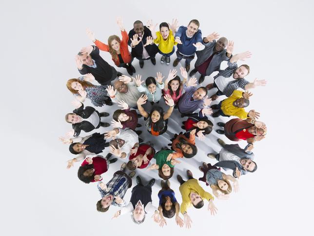 young people standing in concentric circles looking up to camera overhead