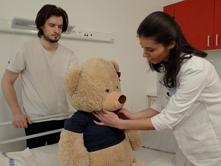 Student doctors practising clinical skills on a plush bear