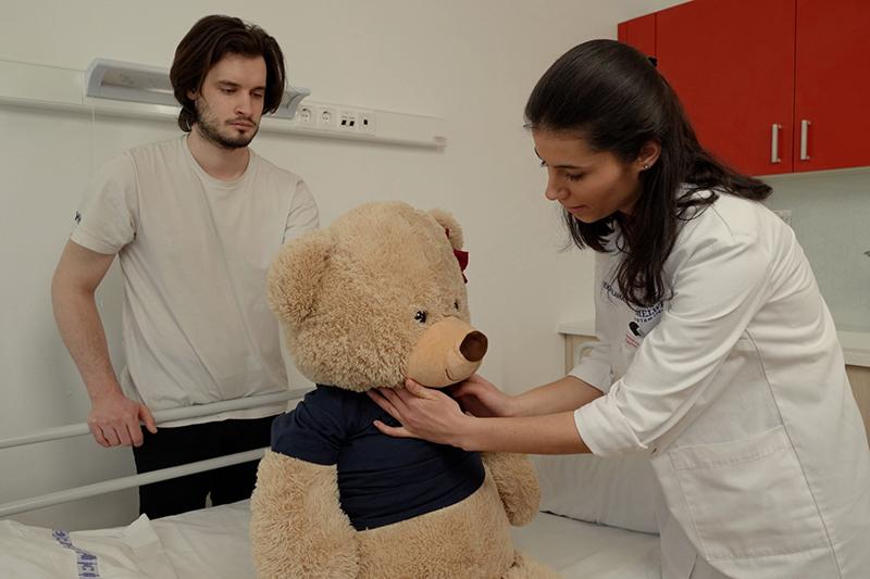 Student doctors practising clinical skills on a plush bear