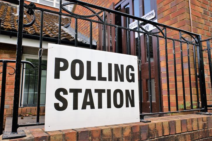 A sign on black railings reads "Polling Station"