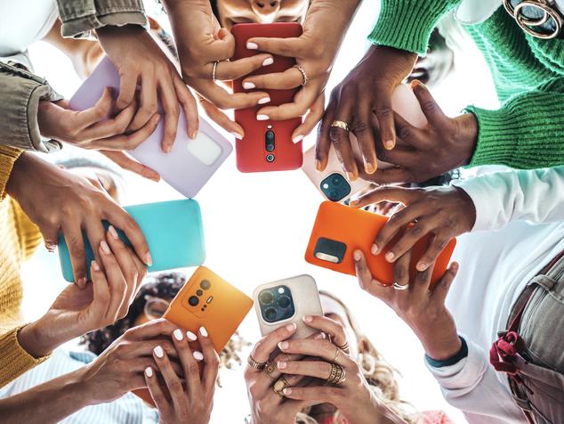 A group of students using smartphones with brightly coloured shells