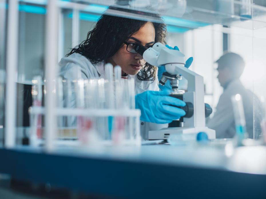 Researcher looking through a microscope in a lab