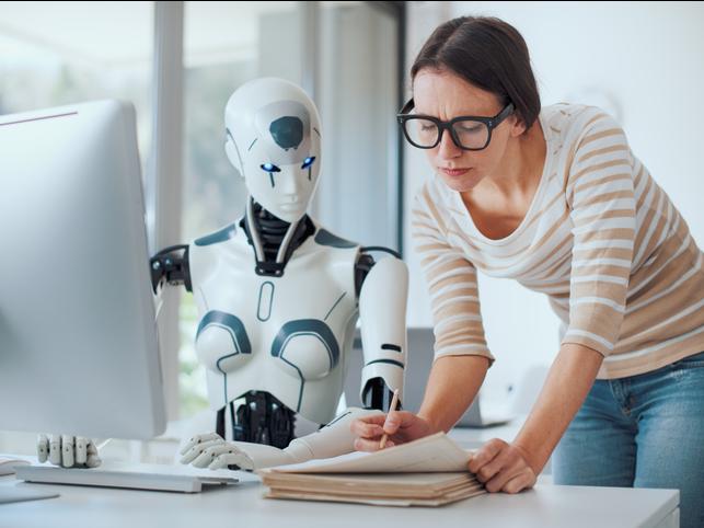 Woman working at computer with robot