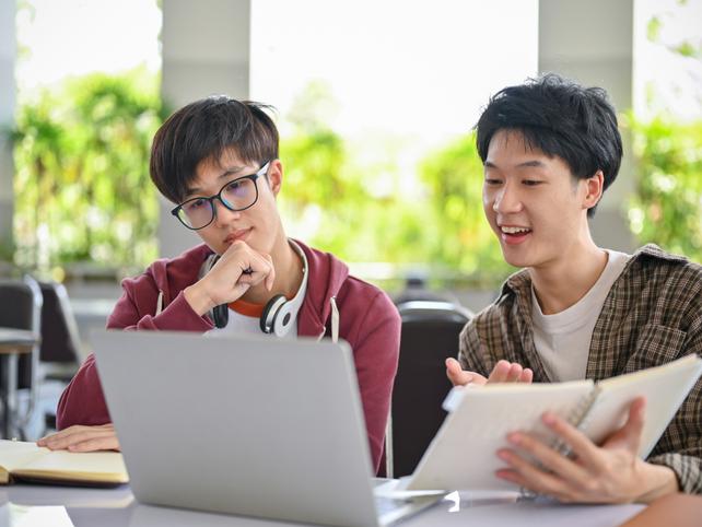 Two male Asian students working together