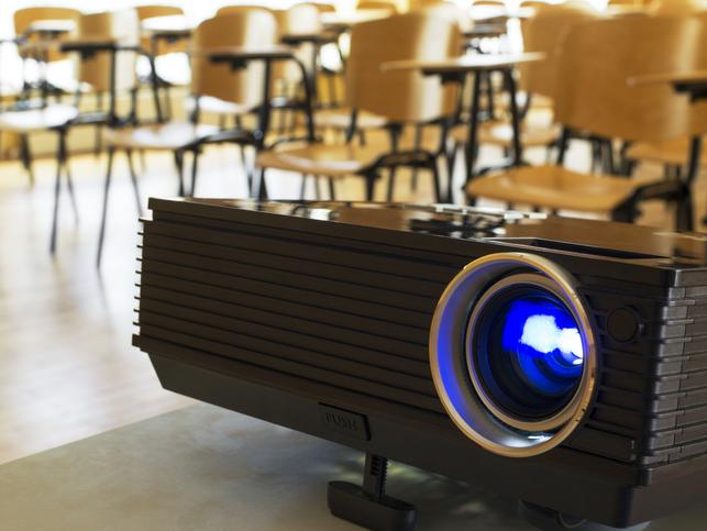 A digital projector sits in a classroom