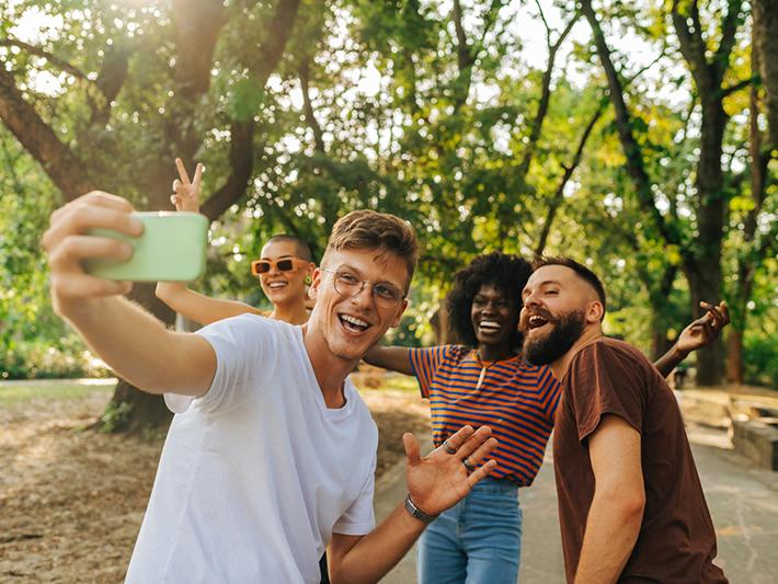 Multiracial group of students taking a selfie in the park