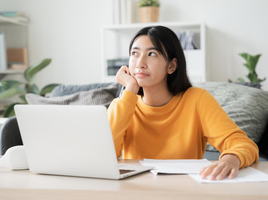 A student at her laptop deep in thought