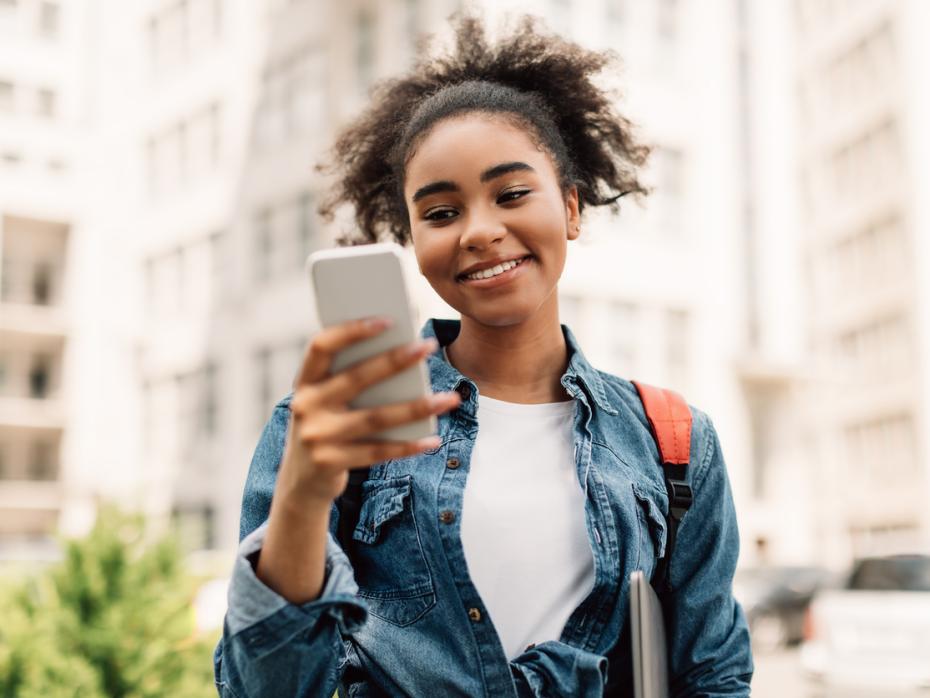 A university student on her phone outside a campus building