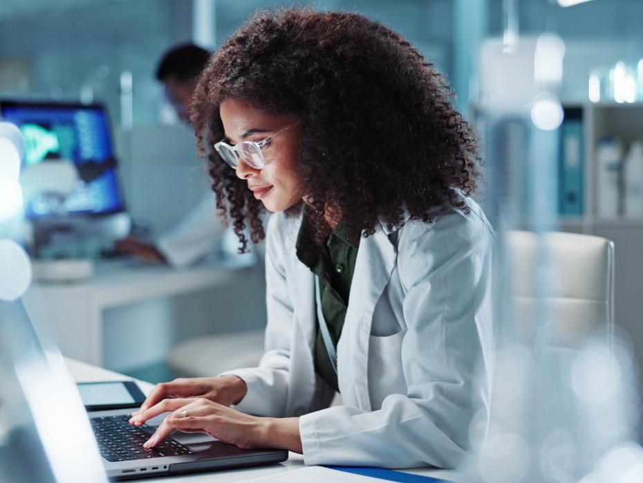 Female researcher working on her laptop in a lab