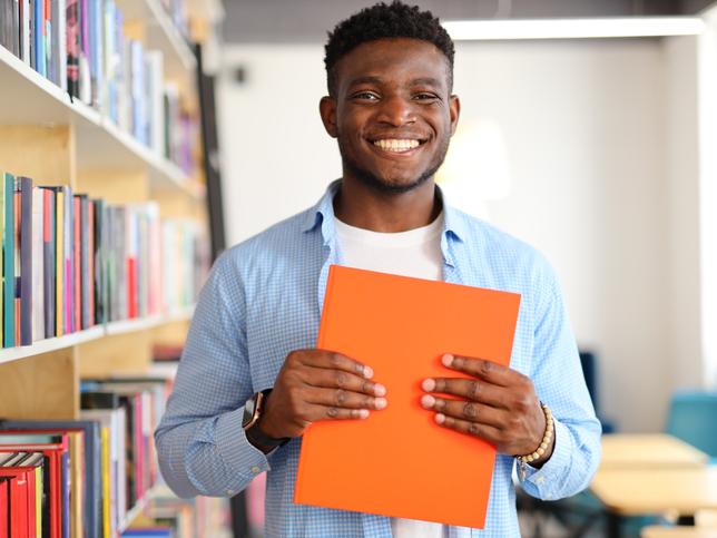 A student in the library holds a book