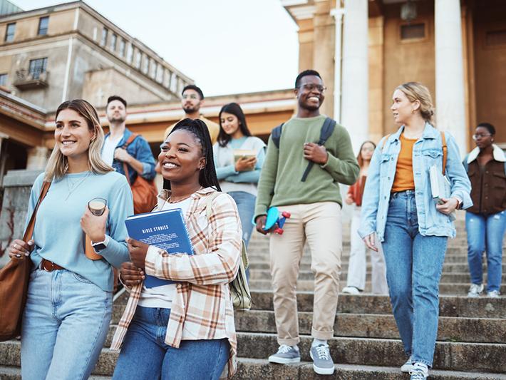 multiracial group of students on university steps