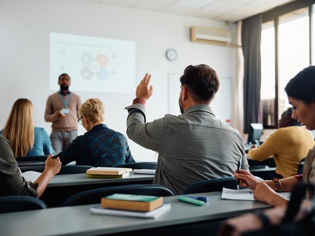 A student raises a hand in a classroom