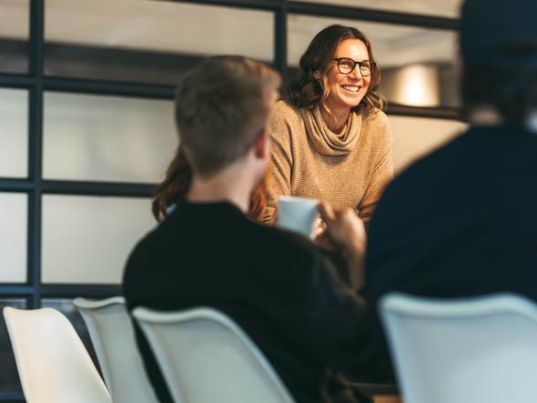 A woman stands up in front of a boardroom table