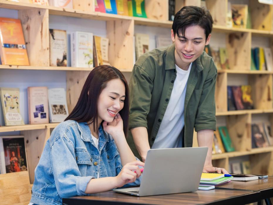 East asian students in a library working together