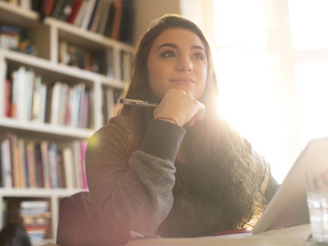 A student looks thoughtfully into the distance