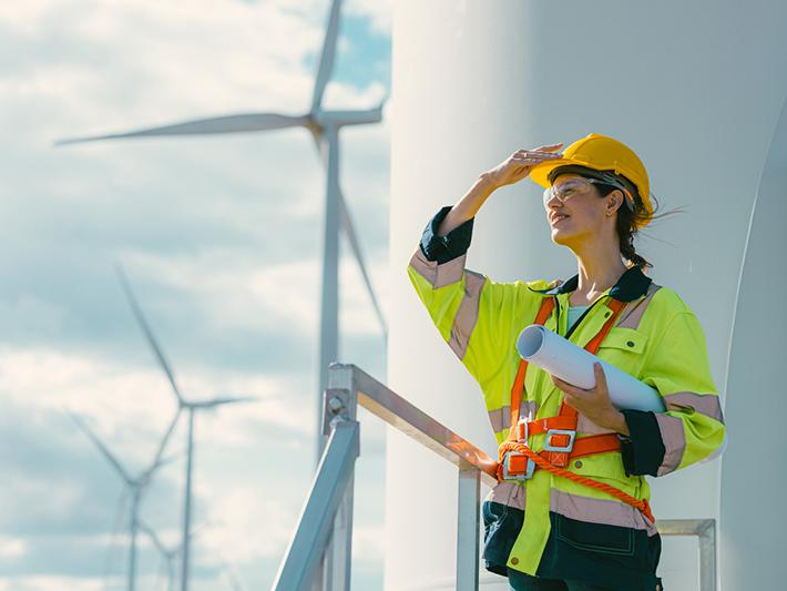 Young female engineer with wind turbines