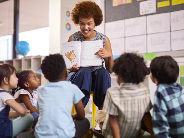 A teacher reads a story to her primary school class