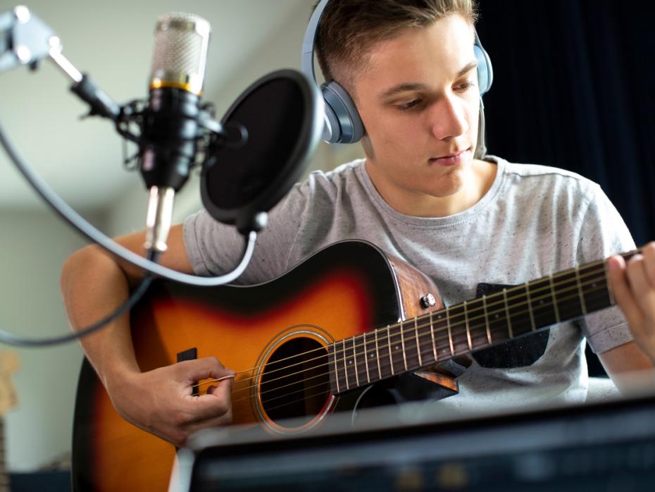 Young man playing guitar in studio