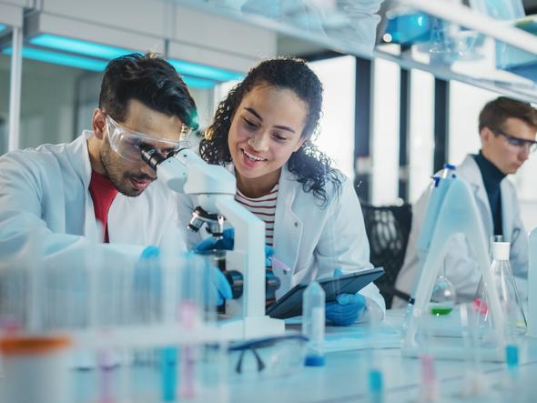 Two science students use a microscope together