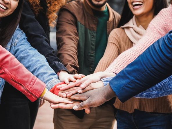 A group of people put their hands together