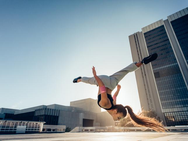 Female athlete performing a backflip outdoors
