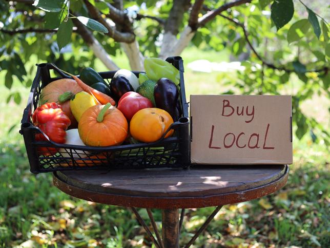 Basket of pumpkins with sign "buy local"