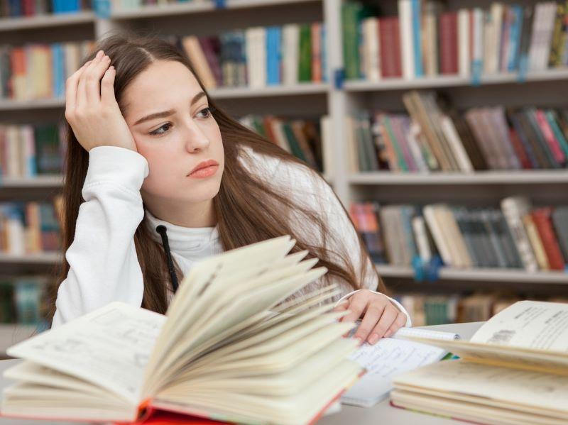 Female student looking distracted from her work