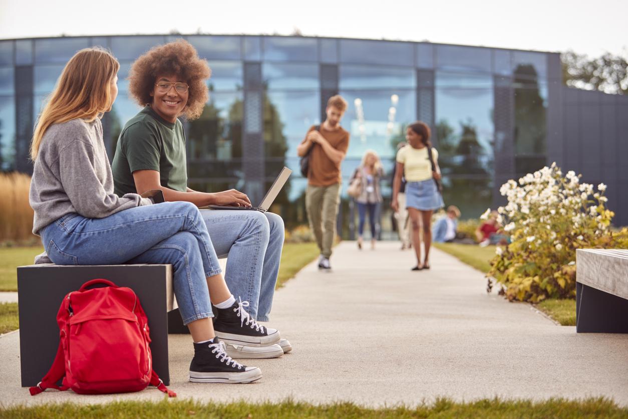Students sitting outside on campus chatting