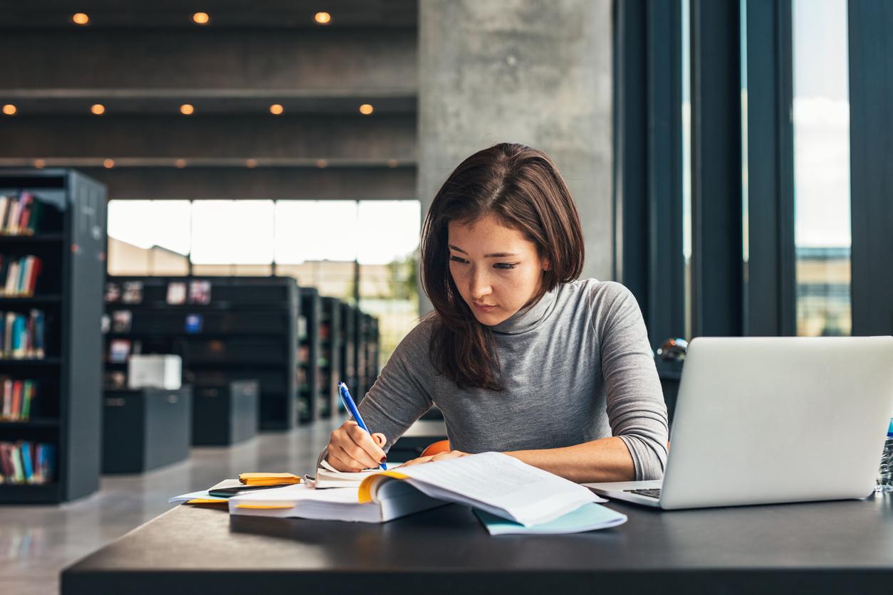 writing in the university A young woman working in a library