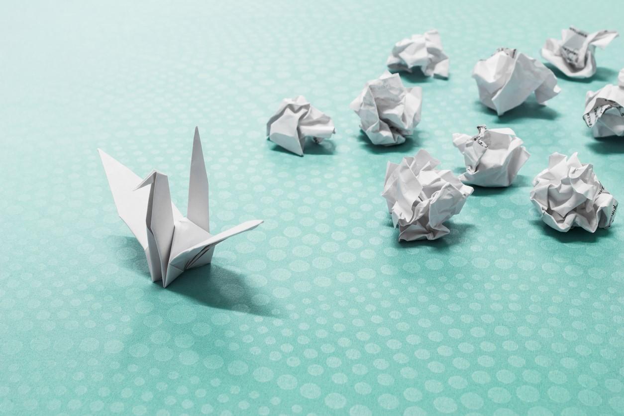 Image of paper balls with one emerging as an origami swan