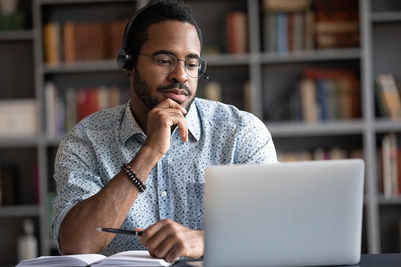 assignment in distance education African American man at a laptop