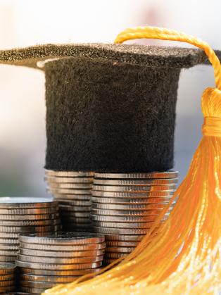 A motarboard sits atop a pile of coins
