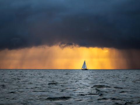 Sailing boat under stormy skies
