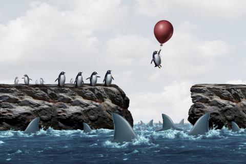 Illustration of penguin ballooning over sharks, risk and uncertainty concept