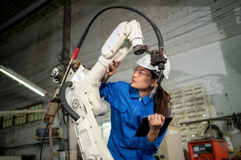 Asian woman working with robot arm