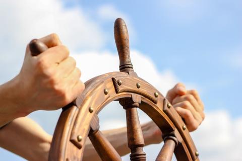 Hands on a ship's wheel