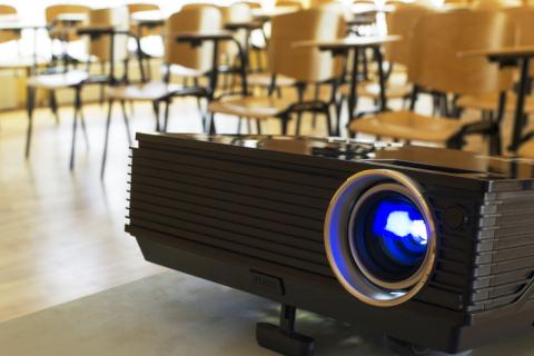 A digital projector sits in a classroom