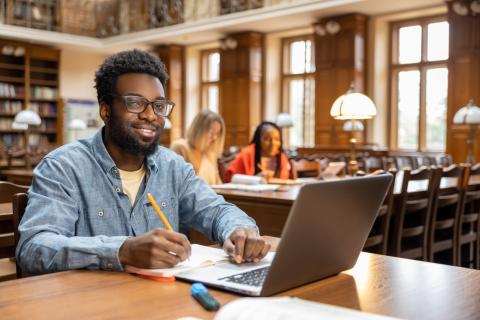 Young man wearing headphones while working on a laptop