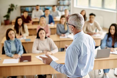 A teacher giving a lecture at the front of class