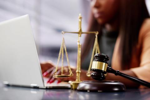 black woman at laptop with scales and gavel, law studies