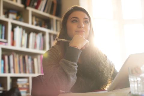 A student looks thoughtfully into the distance