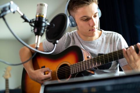 Young man playing guitar in studio