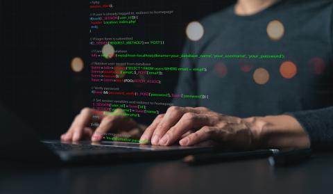 A computer science studeng coding on her laptop