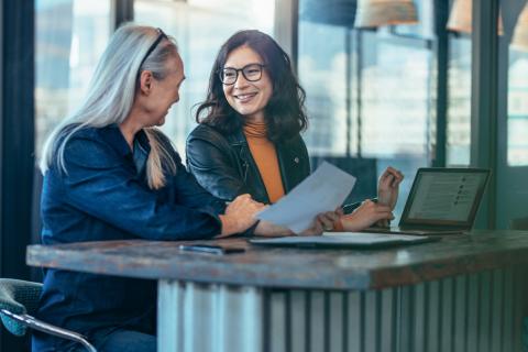 Older woman mentoring young Asian female university student