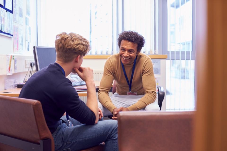 A university tutor talking to a male student