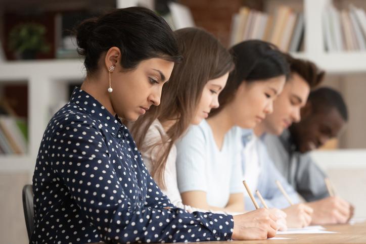 A row of students each concentrating on an individual assignment