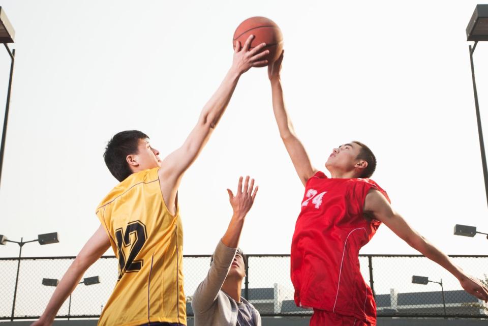 Two men competing in basketball