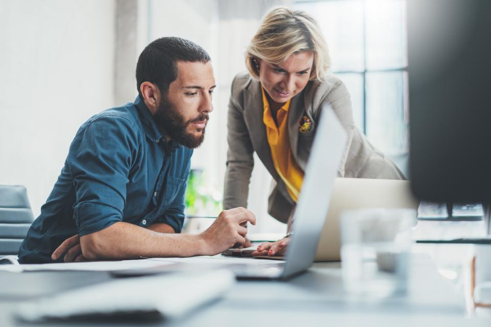 Two colleagues working together at a computer